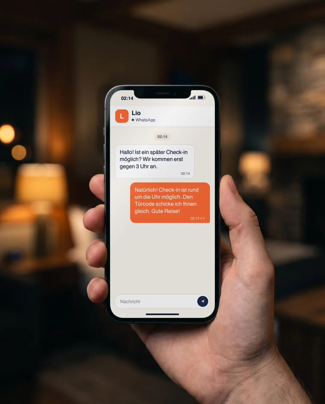 A hand holding a phone showing Lio's WhatsApp reply to a guest writing in German